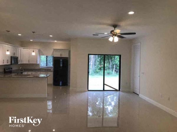a large empty kitchen with a ceiling fan