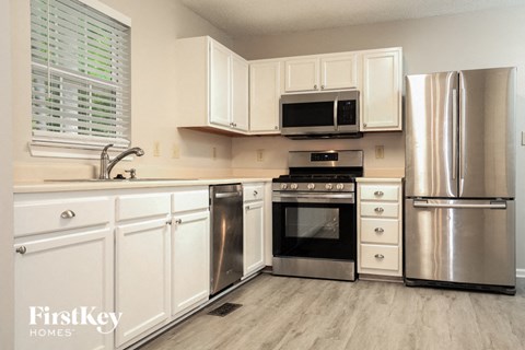 A kitchen with white cabinets and stainless steel appliances.