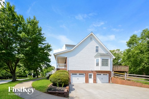 a white house with two garage doors and a driveway