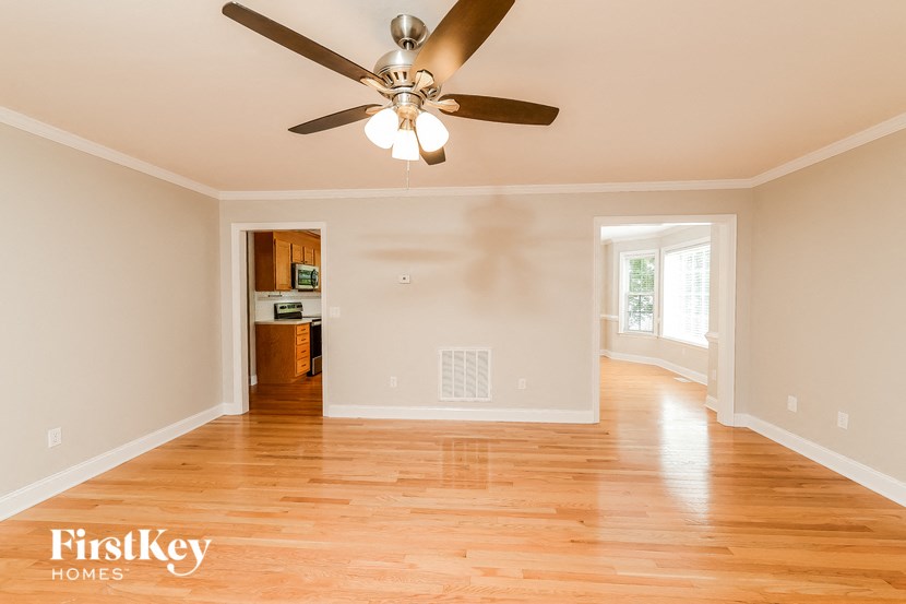 an empty living room with a ceiling fan