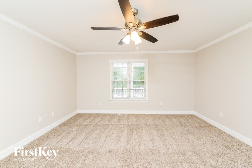 a empty living room with a ceiling fan