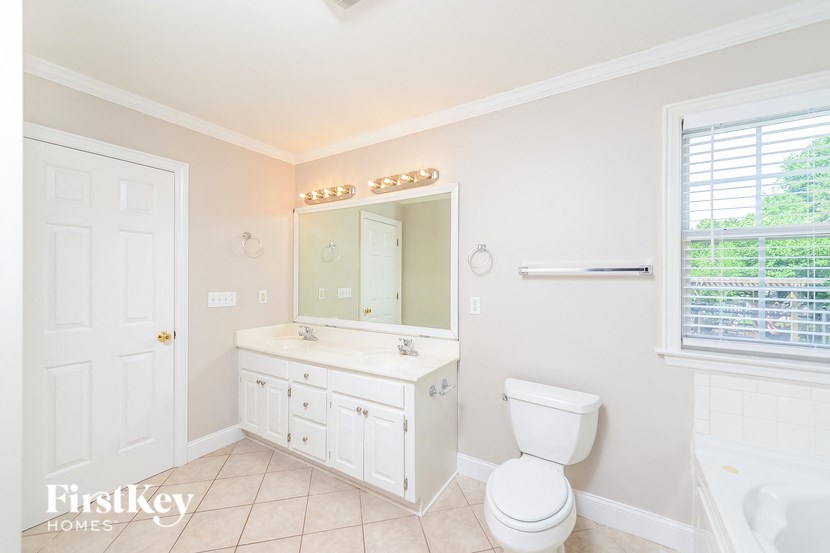 a bathroom with a toilet and a sink and a mirror
