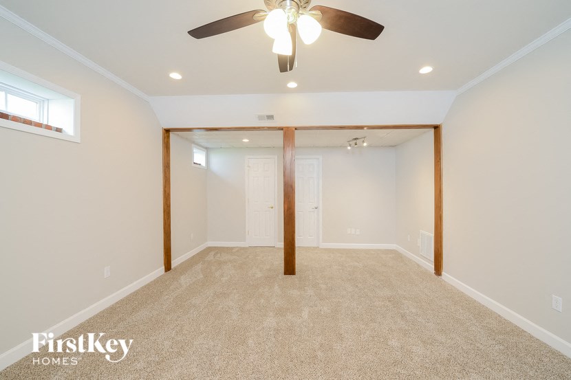 a empty living room with a ceiling fan and a closet