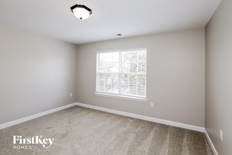 a bedroom with carpet and a large window