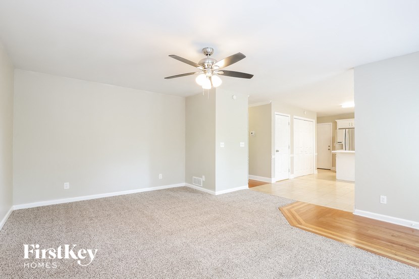 an empty living room with a ceiling fan