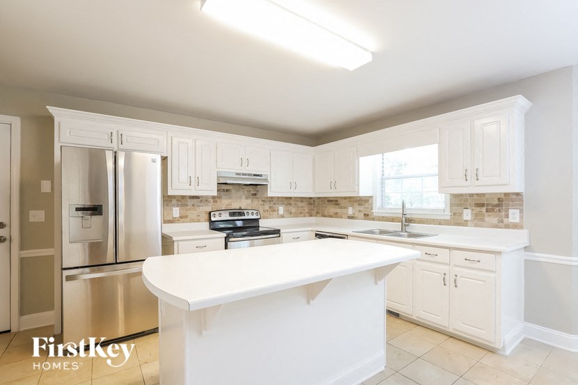 a kitchen with white cabinets and a white counter top