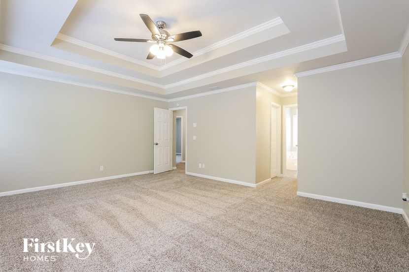 a living room with carpet and a ceiling fan