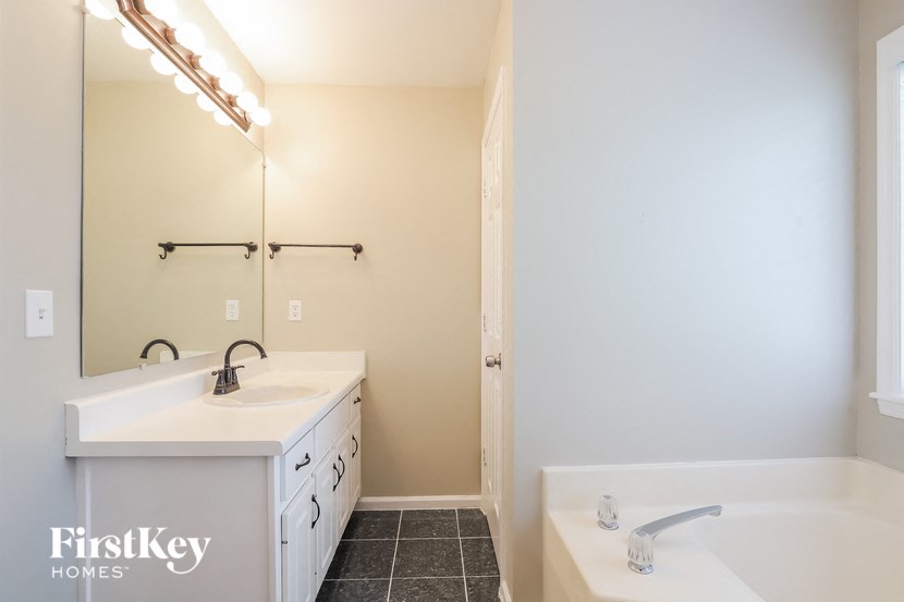 a bathroom with a sink and a tub and a mirror