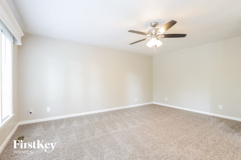 an empty living room with a ceiling fan