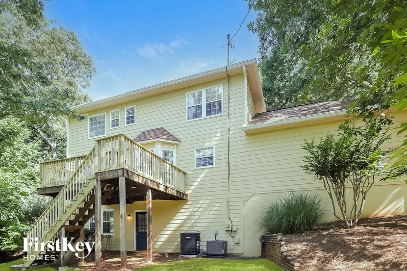 a yellow house with a deck and a staircase