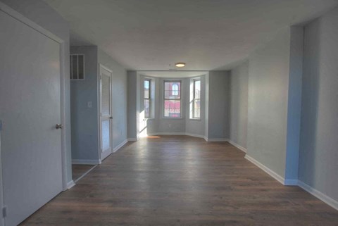 a living room with white walls and a wood floor