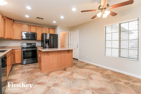 A kitchen with wooden cabinets and a black fridge.