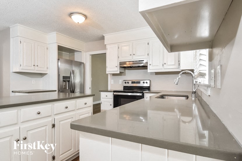 a large kitchen with white cabinets and stainless steel counter tops