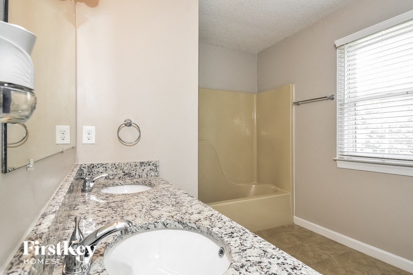 a bathroom with a sink and a shower and a mirror