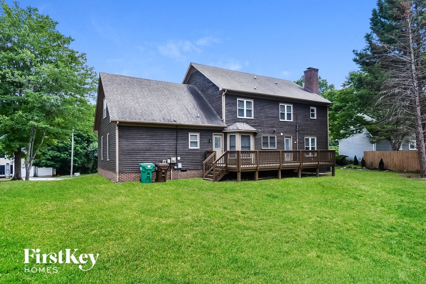 the back of a house with a yard and a deck