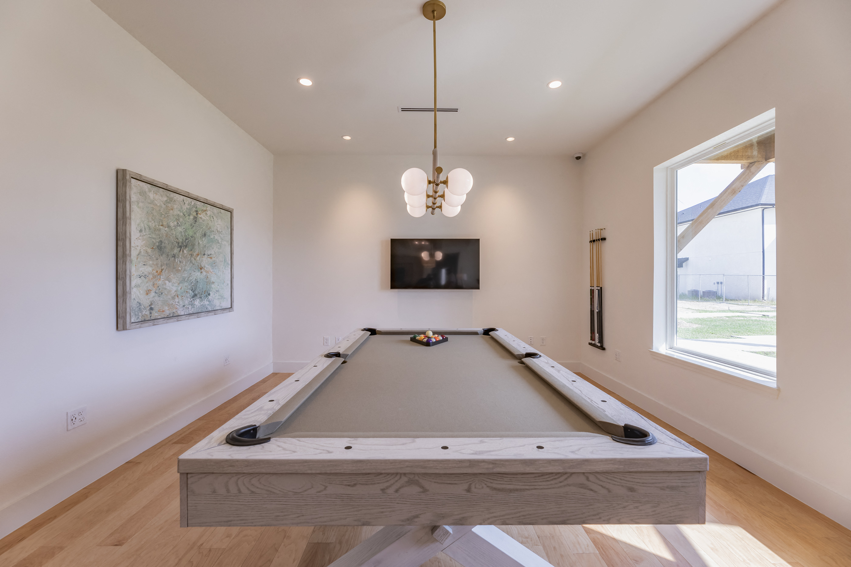 a pool table in a living room with a tv on the wall
