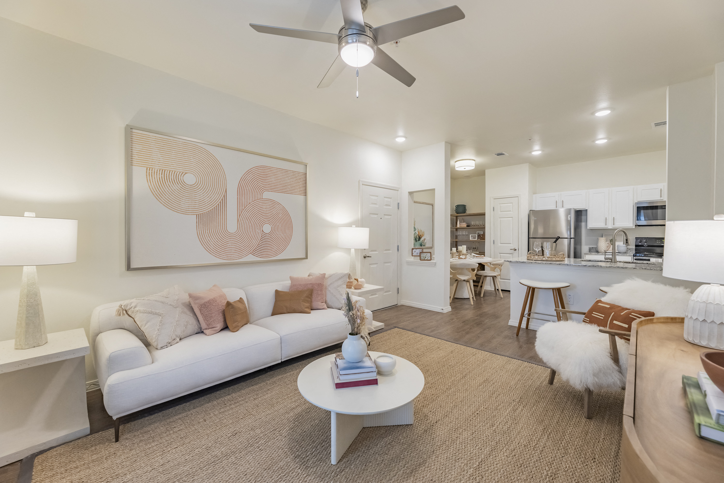 a living room with a white couch and a ceiling fan