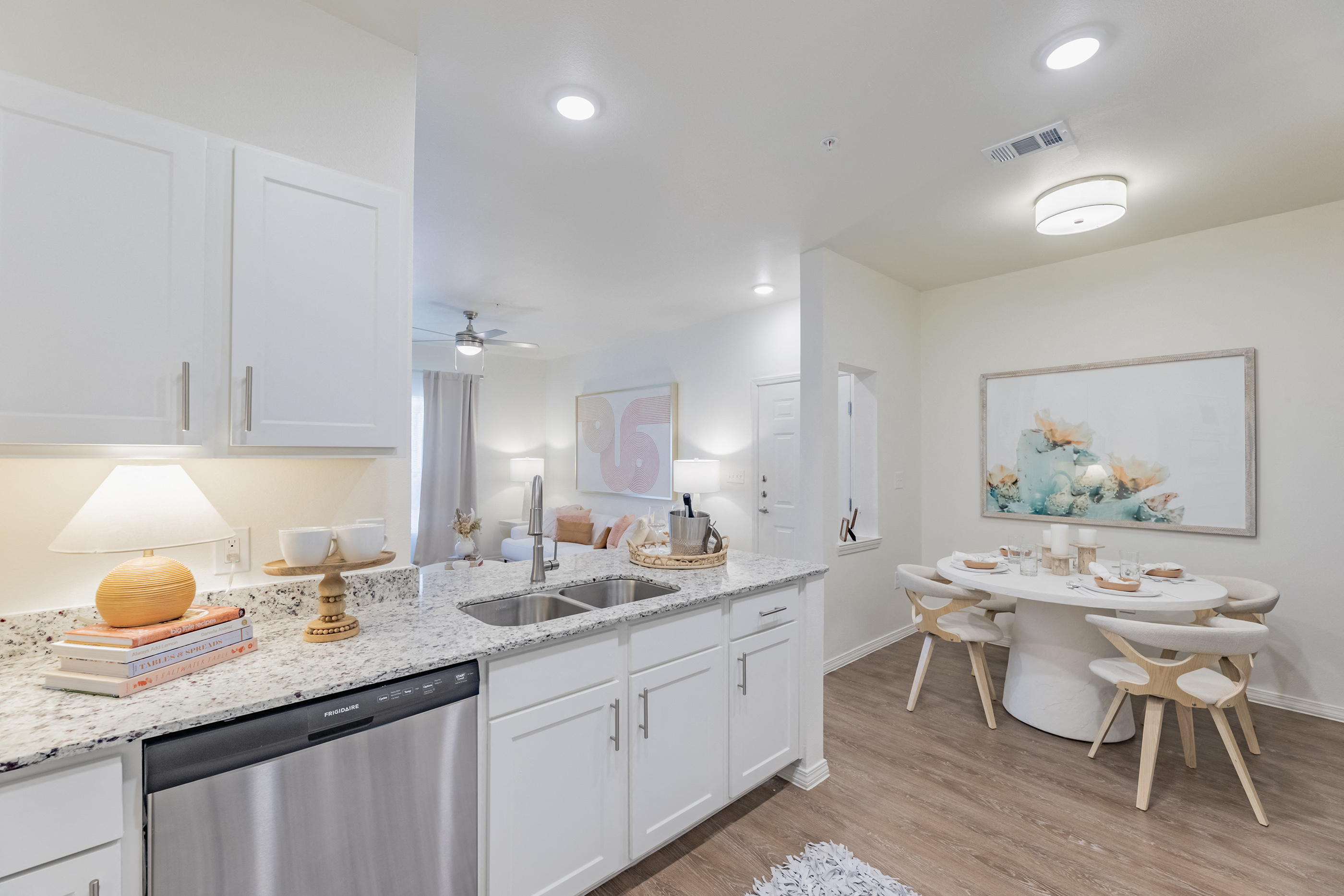 an open kitchen and dining area with a table and chairs and a sink