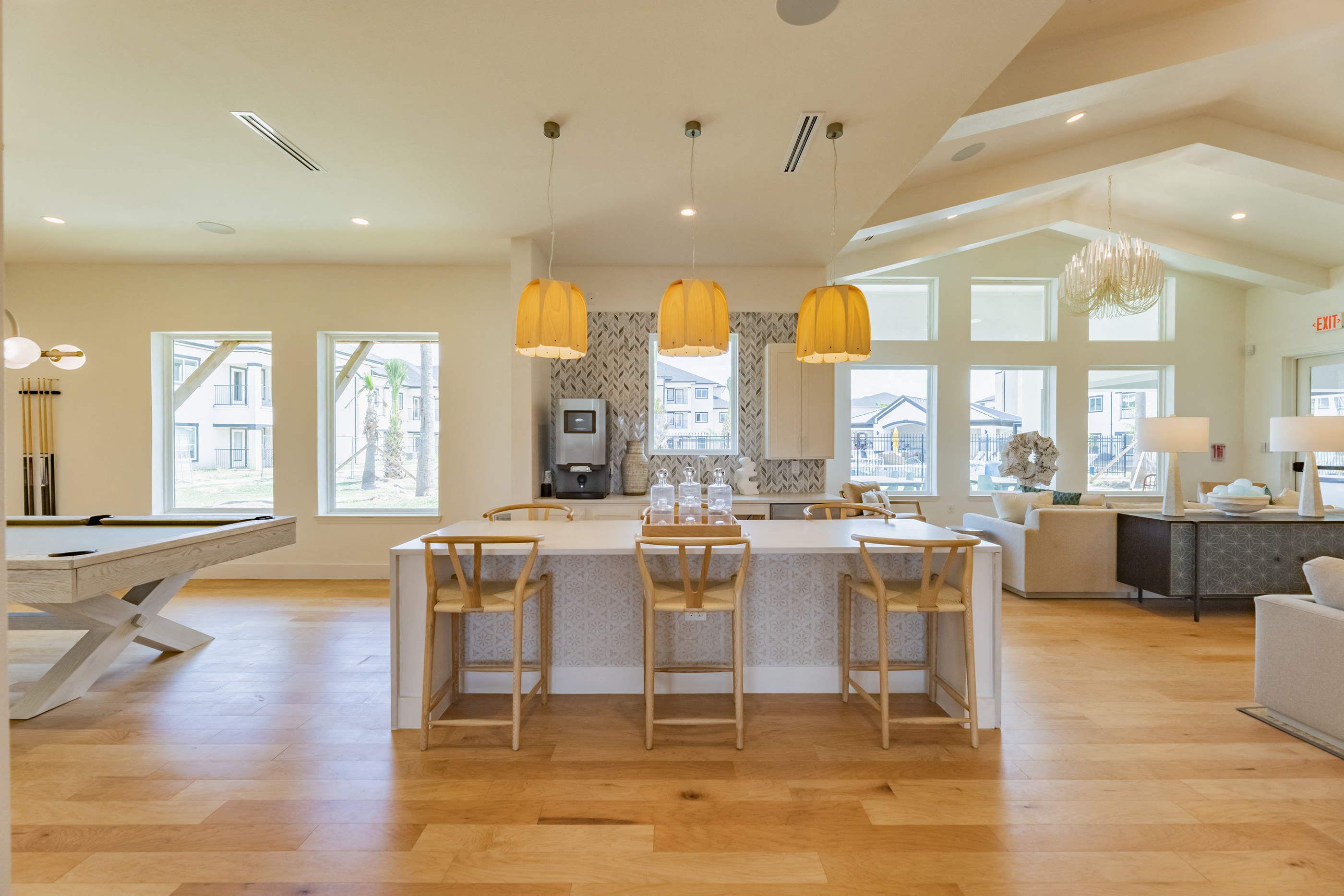 a kitchen with a bar and a living room with a pool table