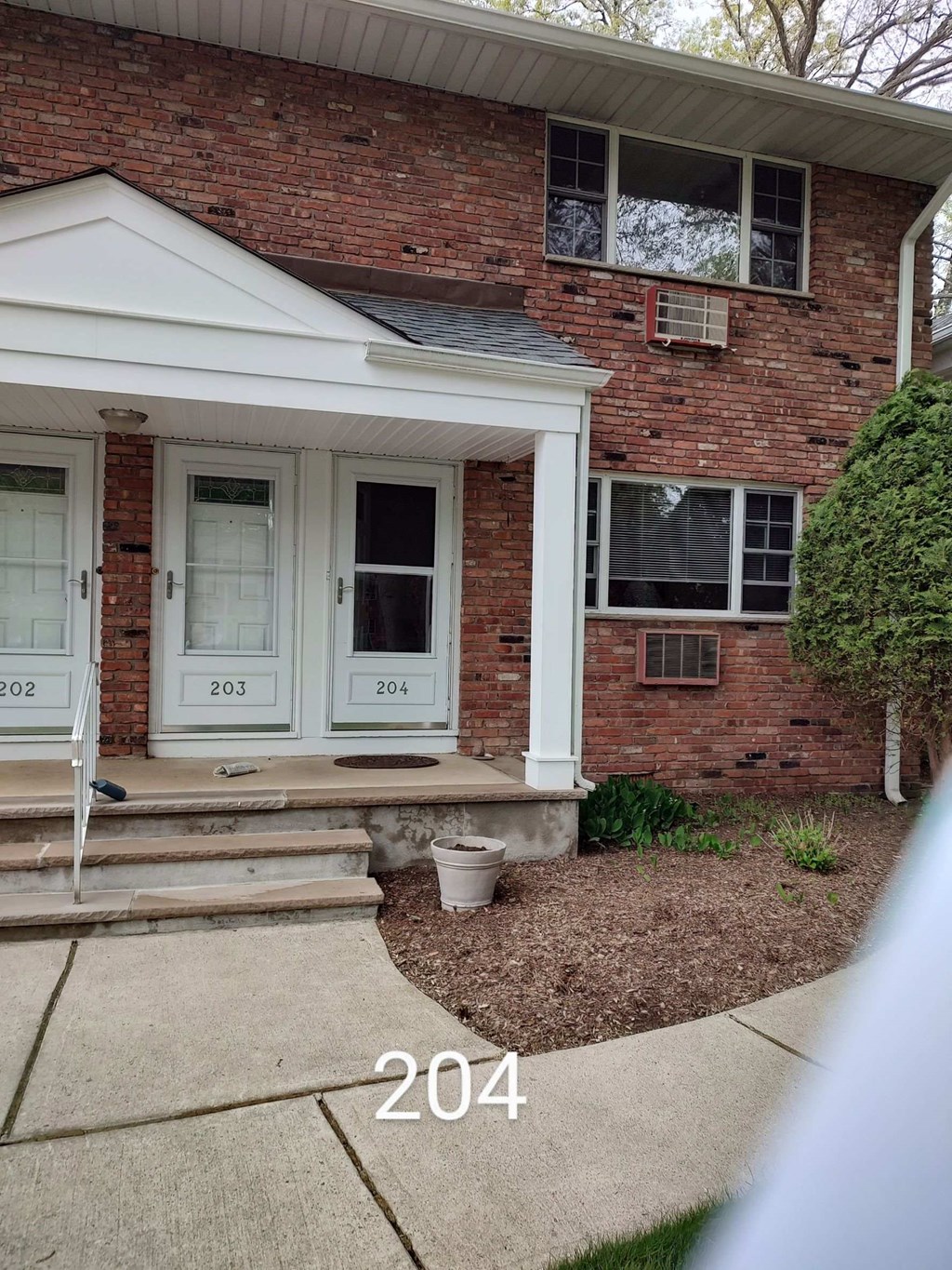 a view of the front of a brick house with white doors