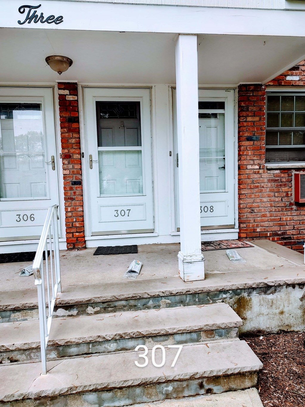 the front door of a house with numbers on the steps
