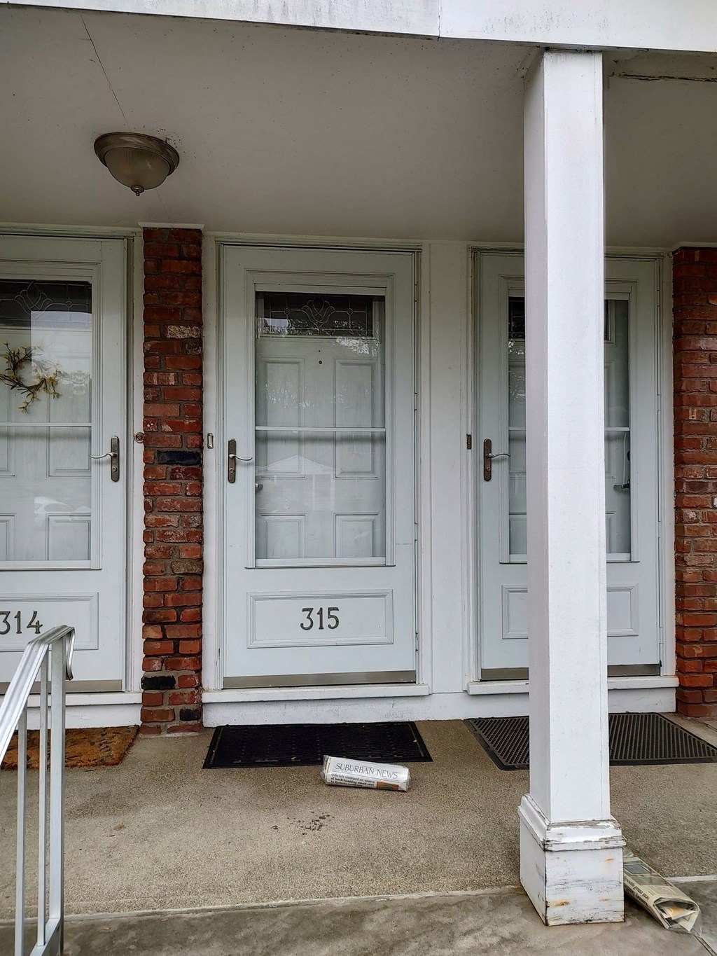 the front door of a brick house with white doors
