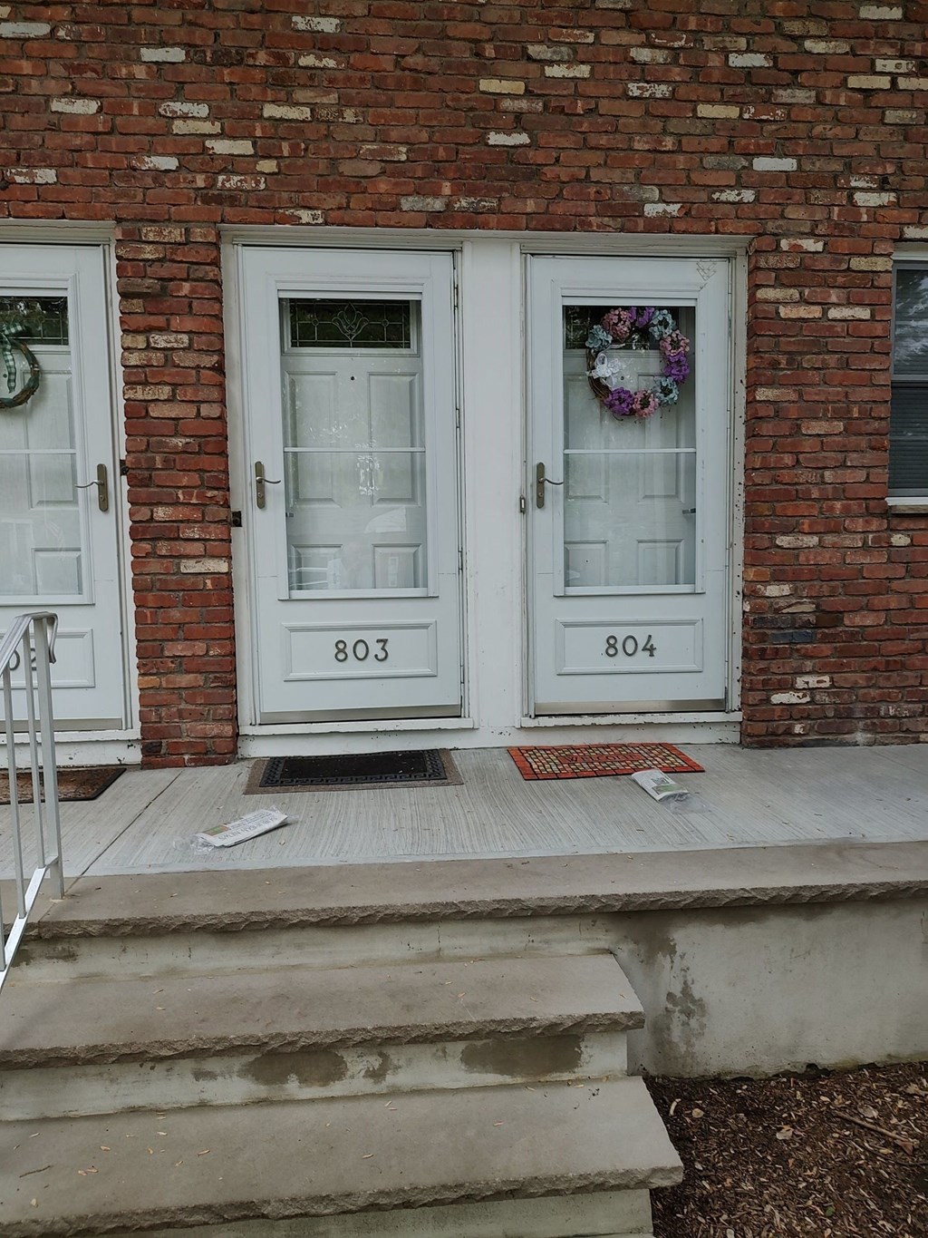 a brick house with two white doors and a porch