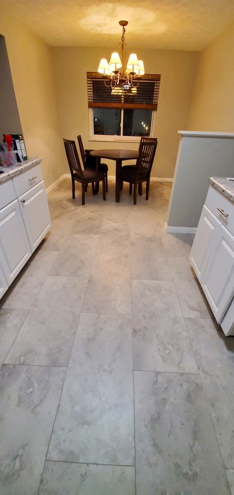 the kitchen and dining area of a home with marble flooring