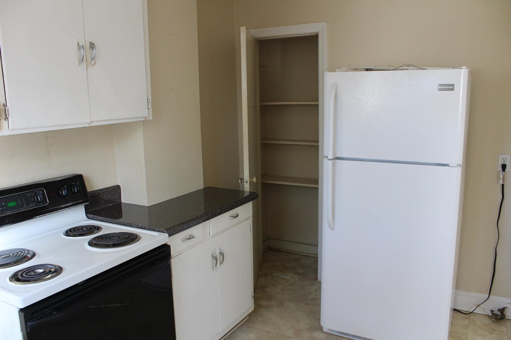 a kitchen with white appliances and a refrigerator