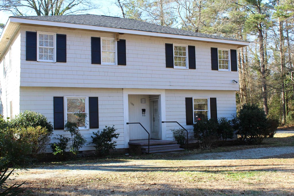 a white house with black shutters and a front porch