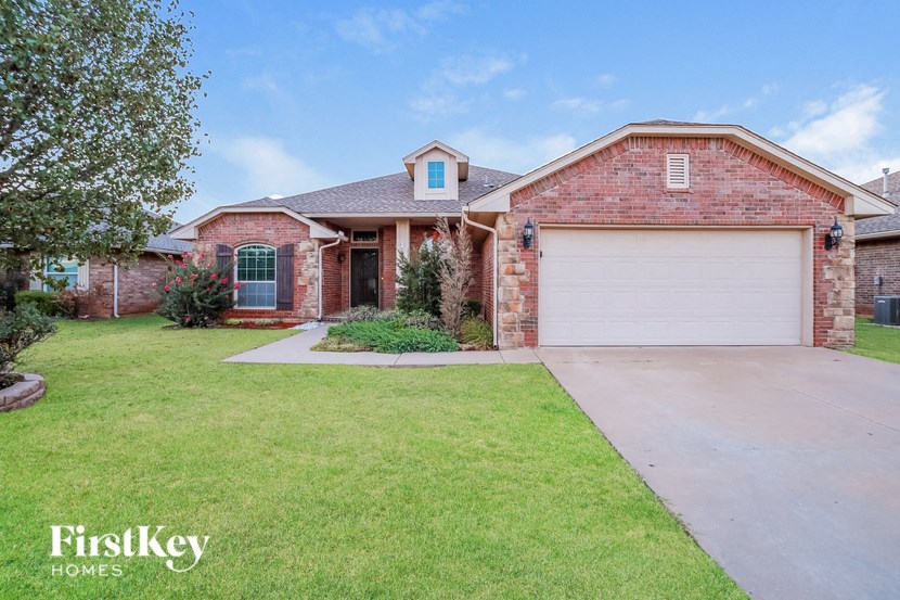 a brick house with a white garage door and a lawn
