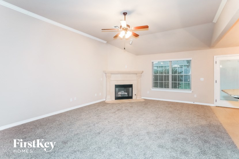 a living room with a fireplace and a ceiling fan