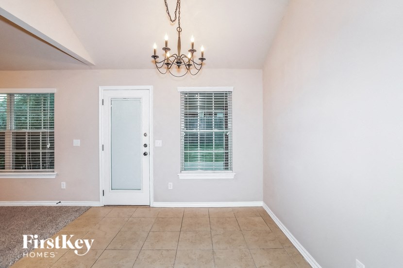 a dining room with a white door and a chandelier