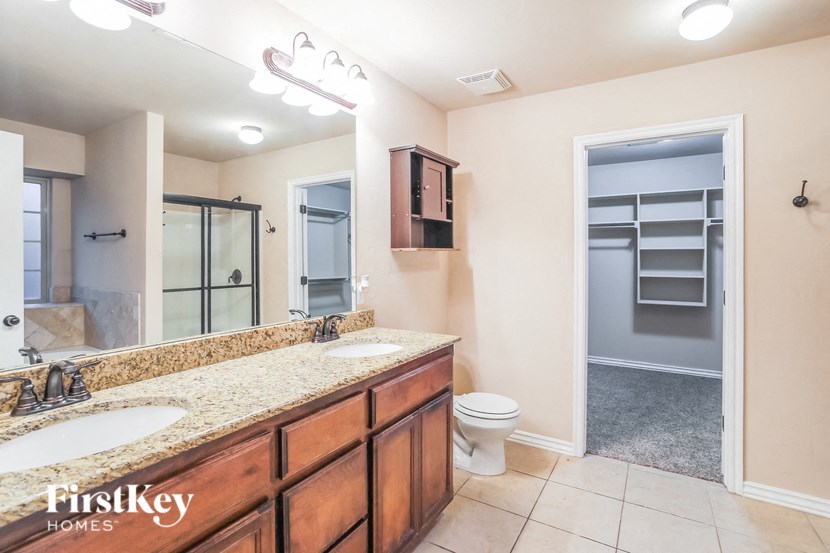 a bathroom with two sinks and a toilet and a shower