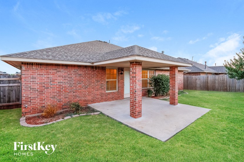 a brick house with a concrete porch and a grass yard