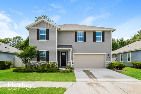 a gray house with blue shutters and a driveway