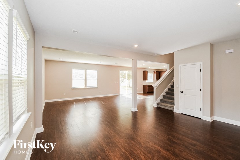 an empty living room with hard wood floors and a staircase