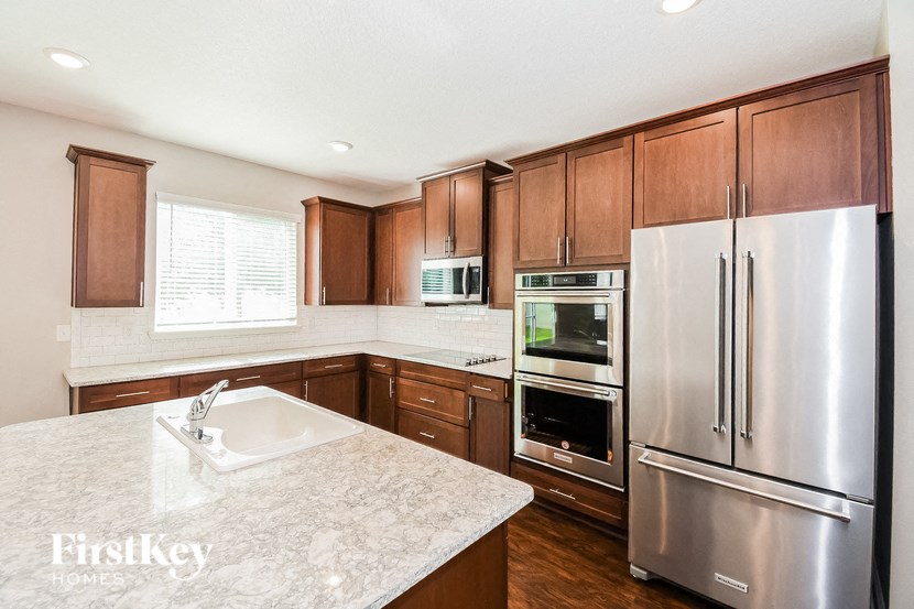 a kitchen with wooden cabinets and stainless steel appliances and granite counter tops