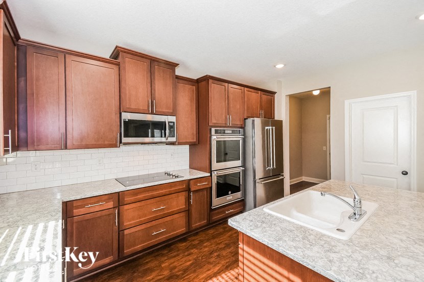 a kitchen with wooden cabinets and granite counter tops and stainless steel appliances
