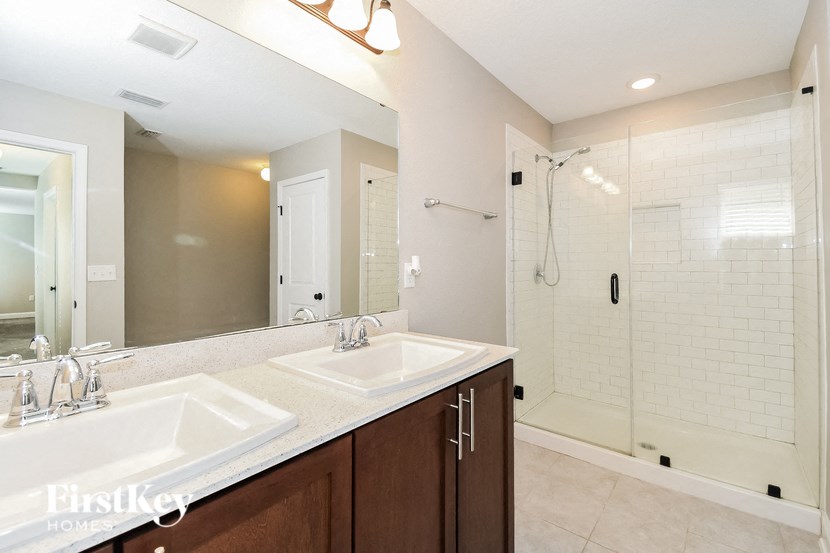a white bathroom with two sinks and a shower