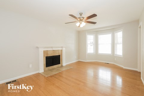 A spacious room with a fireplace and a ceiling fan.