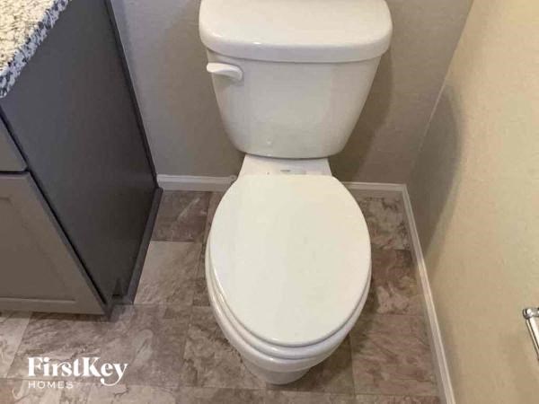 a white toilet in a bathroom with a sink