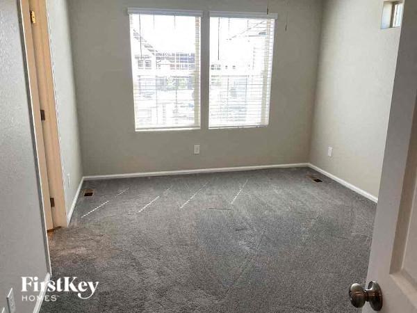 an empty room with a carpeted floor and two windows