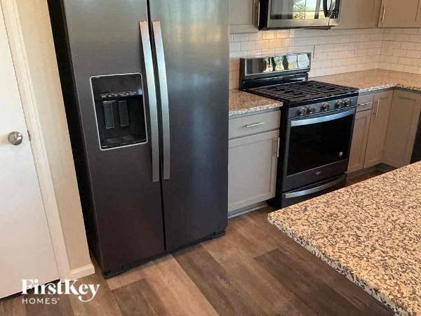 a kitchen with a stainless steel refrigerator and a stove