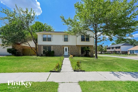 a white and brick house with a blue door on a lawn