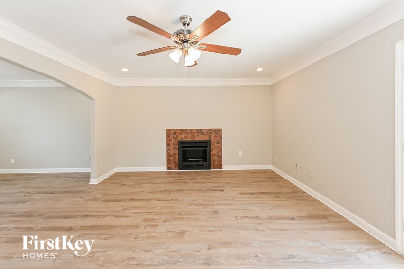 a living room with a fireplace and a ceiling fan