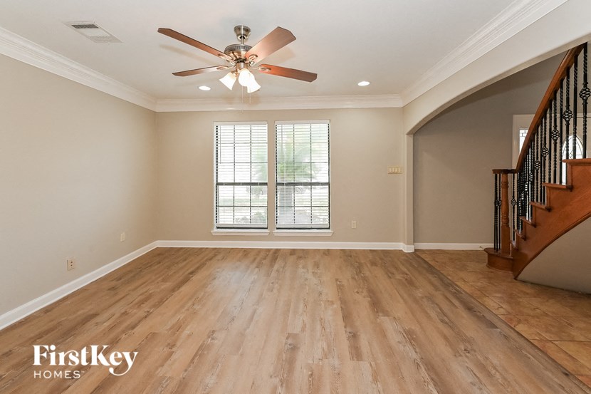 a living room with hardwood floors and a ceiling fan