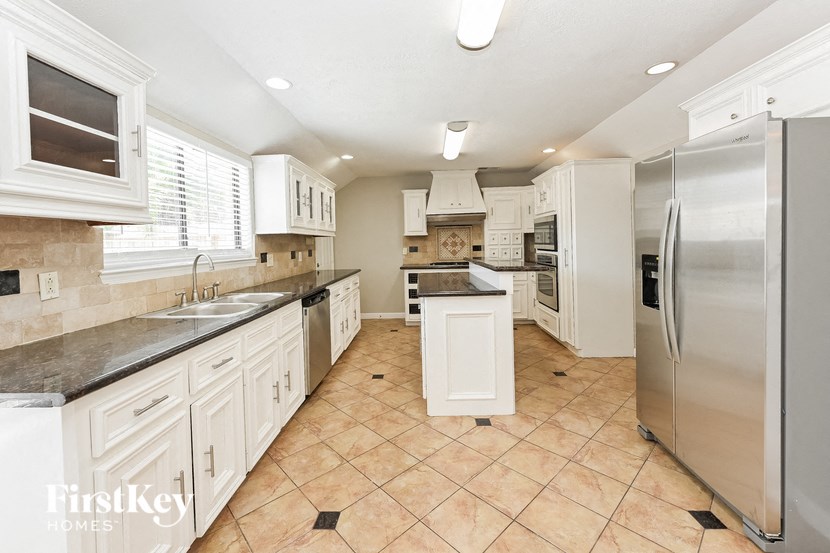 a large kitchen with stainless steel appliances and white cabinets