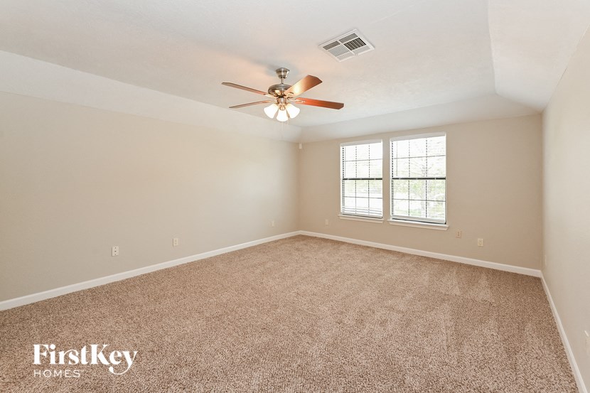 an empty room with a ceiling fan and a window