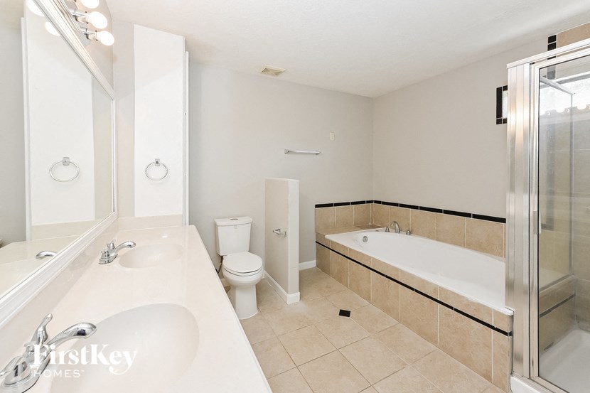 a white bathroom with a tub and a sink and a toilet